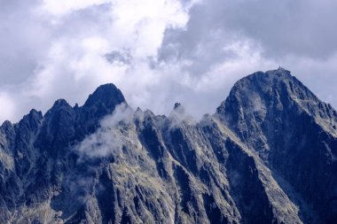 bulutlar ve sis yukarıdan ve yağmur bulutları ile keskin kayalık dağ başında Slovakya'daki Tatra Dağları'nda. Rysy dağın.
