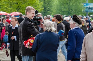 Riga, Letonya, 9 Mayıs 2008 - Riga gösteride Sovyet Dünya Savaşı 2, Sovyet bayrakları çiçek Döşeme ve kameralar önünde gülümseyen insanlarla zaferle ilgili