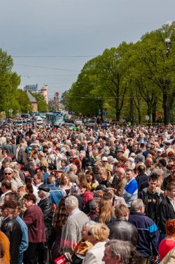 Riga, Letonya, 9 Mayıs 2008 - Riga gösteride Sovyet Dünya Savaşı 2, Sovyet bayrakları çiçek Döşeme ve kameralar önünde gülümseyen insanlarla zaferle ilgili