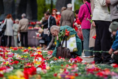 Riga, Letonya, 9 Mayıs 2008 - Riga gösteride Sovyet Dünya Savaşı 2, Sovyet bayrakları çiçek Döşeme ve kameralar önünde gülümseyen insanlarla zaferle ilgili