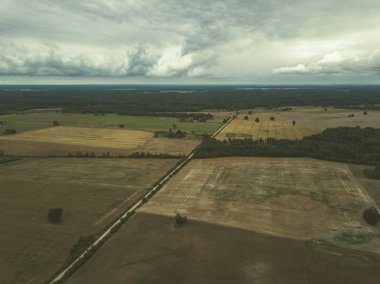 Kırsal alanın alanları ve ormanlar dramatik fırtına bulutları oluşturan altında havadan görünümü