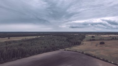 Kırsal alanın alanları ve ormanlar dramatik fırtına bulutları oluşturan altında havadan görünümü