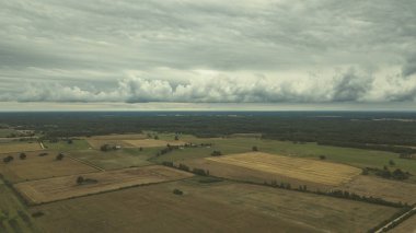 Kırsal alanın alanları ve ormanlar dramatik fırtına bulutları oluşturan altında havadan görünümü