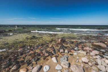 güneşli bir gün sahilde kayalık deniz