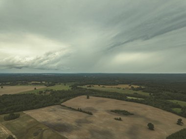 Kırsal alanın alanları ve ormanlar dramatik fırtına bulutları oluşturan altında havadan görünümü