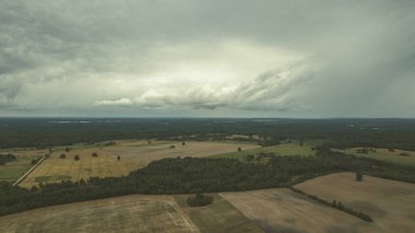 Kırsal alanın alanları ve ormanlar dramatik fırtına bulutları oluşturan altında havadan görünümü