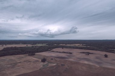 Kırsal alanın alanları ve ormanlar dramatik fırtına bulutları oluşturan altında havadan görünümü
