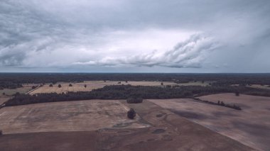 Kırsal alanın alanları ve ormanlar dramatik fırtına bulutları oluşturan altında havadan görünümü