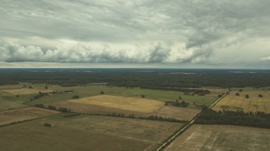 Kırsal alanın alanları ve ormanlar dramatik fırtına bulutları oluşturan altında havadan görünümü