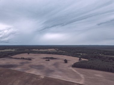 Kırsal alanın alanları ve ormanlar dramatik fırtına bulutları oluşturan altında havadan görünümü