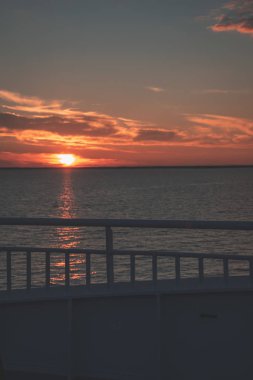 Baltık Denizi gemi halatları ve metal parmaklıklar üzerinde dramatik kırmızı gündoğumu