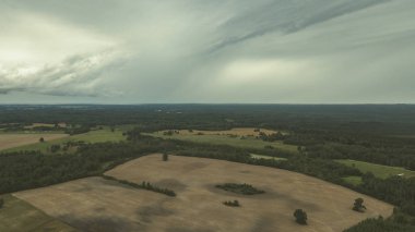 Kırsal alanın alanları ve ormanlar dramatik fırtına bulutları oluşturan altında havadan görünümü