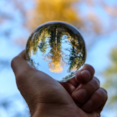 lensball çevresinde doğa yansıtan Güz. insan eli ambarda renkler sonbahar