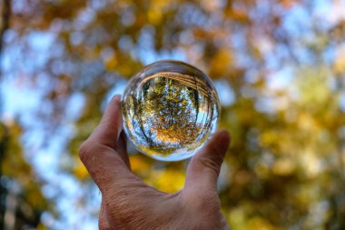 lensball çevresinde doğa yansıtan Güz. insan eli ambarda renkler sonbahar