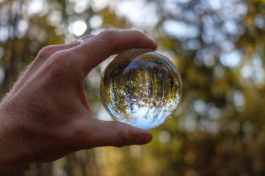 lensball çevresinde doğa yansıtan Güz. insan eli ambarda renkler sonbahar