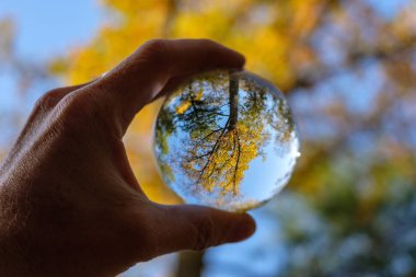 lensball çevresinde doğa yansıtan Güz. insan eli ambarda renkler sonbahar