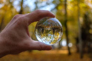 lensball çevresinde doğa yansıtan Güz. insan eli ambarda renkler sonbahar