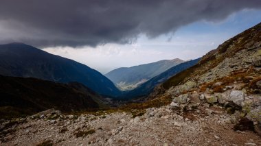 dağ panorama Banikov tepe Slovakça Tatra Dağları rocky manzara ile üst ve gölgeler bulutlu günde yaklaşan fırtına bulutları ile parlak günde yürüyüşçü