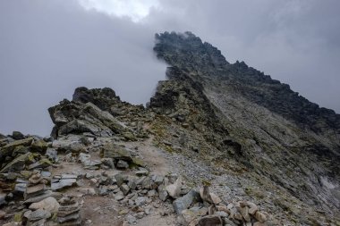 Rysy en yüksek dağ sis kaplı. Sonbahar yokuş üzerinde kayalık yürüyüş parkurları. Slovakya ve Polonya sınırı