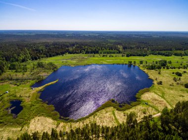 drone görüntü. alanları ve ormanları ve bulutlu bahar günü nehir su yansımalar kırsal alan hava görünümünü. Letonya