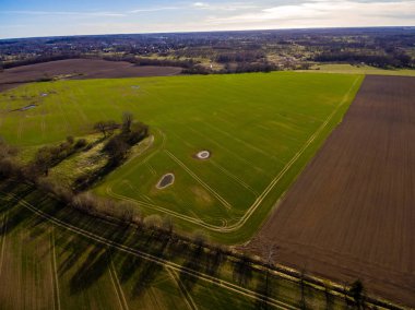 drone görüntü. alanları ve ormanları ve bulutlu bahar günü nehir su yansımalar kırsal alan hava görünümünü. Letonya