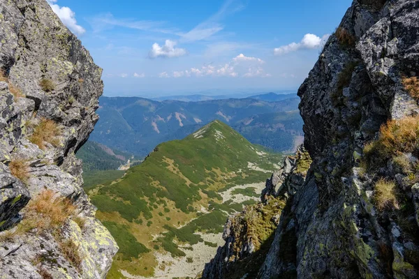 rocky mountain tops with hiking trails in autumn in Slovakian Tatra western Carpathian with blue sky and late grass on  hills. Empty rocks in bright daylight, far horizon for adventures.