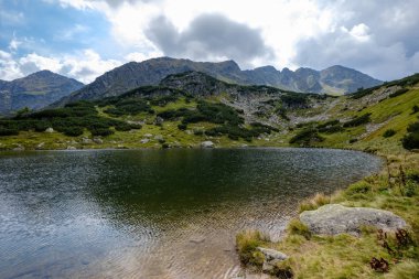 dağ Gölü geç yaz aylarında Slovakça Karpat Tatra'panorama görünümünü su kayalık tepede yansımaları ile. Zverovka köyü yakınındaki Rohacske plesa göller.