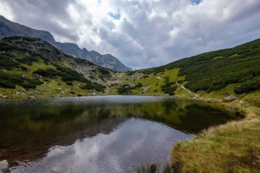 dağ Gölü geç yaz aylarında Slovakça Karpat Tatra'panorama görünümünü su kayalık tepede yansımaları ile. Zverovka köyü yakınındaki Rohacske plesa göller.