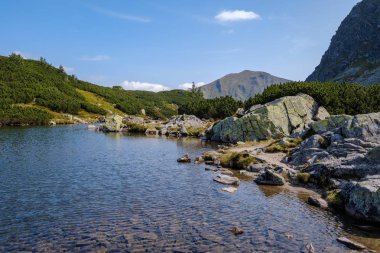 dağ Gölü geç yaz aylarında Slovakça Karpat Tatra'panorama görünümünü su kayalık tepede yansımaları ile. Zverovka köyü yakınındaki Rohacske plesa göller.