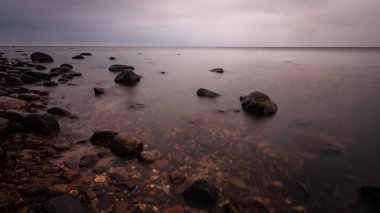 deniz kaya ile plaj ve su dalgalar yıkanmış. dokulu soyut resim, uzun pozlama
