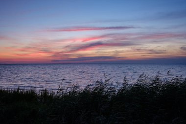 Estonya sakin su ve güneş yansımaları ile Baltık Denizi üzerinde güzel gün batımı