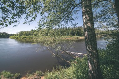 sakin Nehri yakınındaki Cesis, Letonya ağaçlarının yansımaları ile. Gauja Nehri