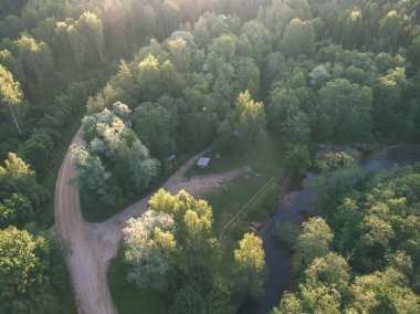 drone görüntü. alanları ve ormanları ve bulutlu bahar günü nehir su yansımalar kırsal alan hava görünümünü. Letonya - vintage eski film bakmak