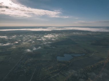drone görüntü. hava alanları ve ormanları ile kırsal alan görünümünü sonbahar sis kaplı. Letonya - vintage eski film bakmak