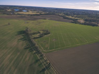 drone görüntü. alanları ve ormanları ve bulutlu bahar günü nehir su yansımalar kırsal alan hava görünümünü. Letonya - vintage eski film bakmak