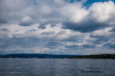 güzel kayalık sahil şeridine Norveç'te sakin su mavi gökyüzü altında