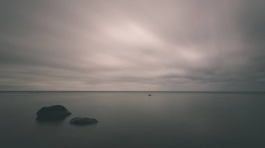 uzun pozlama deniz kaya ile plaj ve su dalgalar yıkanmış. vintage eski film dokulu soyut resim - bak