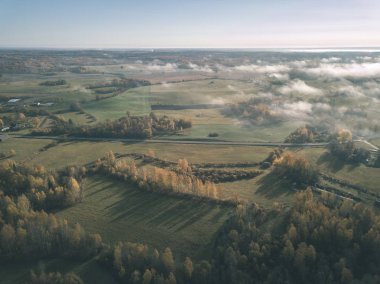 drone görüntü. hava alanları ve ormanları ile kırsal alan görünümünü sonbahar sis kaplı. Letonya - vintage eski film bakmak