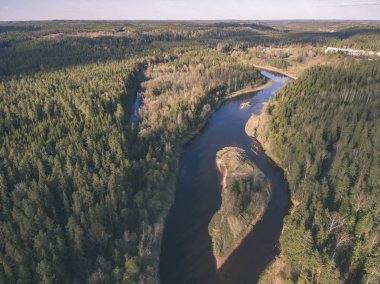 drone görüntü. alanları ve ormanları ve bulutlu bahar günü nehir su yansımalar kırsal alan hava görünümünü. Letonya - vintage eski film bakmak