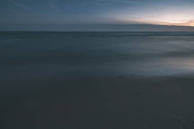 uzun pozlama deniz kaya ile plaj ve su dalgalar yıkanmış. vintage eski film dokulu soyut resim - bak