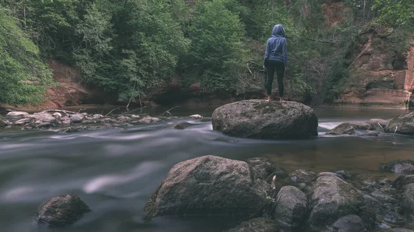 人在蓝色的头套站在岩石上与长曝光岩石山河 — 图库照片
