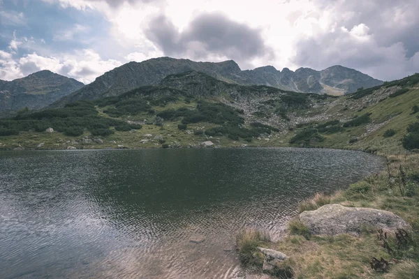 beautiful mountain lake panorama view in late summer in Slovakian Carpathian Tatra mountains with reflections of rocky hills in water. Rohacske plesa lakes near Zverovka village