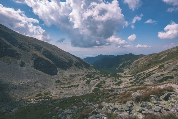 beautiful rocky mountain tops with hiking trails in autumn in Slovakian Tatra western Carpathian mountains with blue sky and late grass on hills. Empty rocks in bright daylight, far horizon for adventures