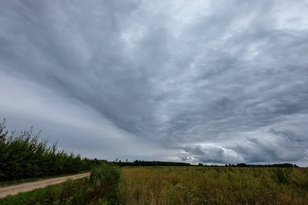 嵐雲の田舎と道路のフィールド形成 — ストック写真