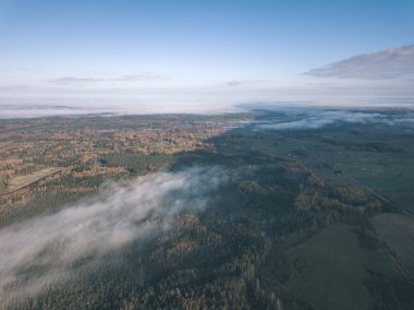 drone görüntü. hava alanları ve ormanları ile kırsal alan görünümünü sonbahar sis kaplı. Letonya - vintage eski film bakmak