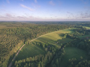 drone görüntü. alanları ve ormanları ve bulutlu bahar günü nehir su yansımalar kırsal alan hava görünümünü. Letonya - vintage eski film bakmak