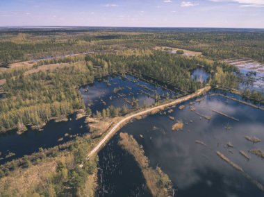 drone görüntü. alanları ve ormanları ve bulutlu bahar günü nehir su yansımalar kırsal alan hava görünümünü. Letonya - vintage eski film bakmak