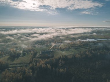 drone görüntü. hava alanları ve ormanları ile kırsal alan görünümünü sonbahar sis kaplı. Letonya - vintage eski film bakmak