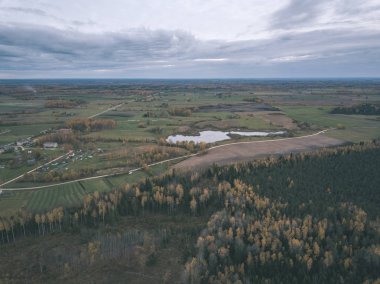 drone görüntü. hava alanları ve ormanları ile kırsal alan görünümünü sonbahar sis kaplı. Letonya - vintage eski film bakmak