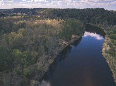 drone görüntü. alanları ve ormanları ve bulutlu bahar günü nehir su yansımalar kırsal alan hava görünümünü. Letonya - vintage eski film bakmak